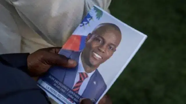 Pessoa segura foto do presidente assassinado do Haiti Jovenel Moise durante seu funeral em Cap-Haitien